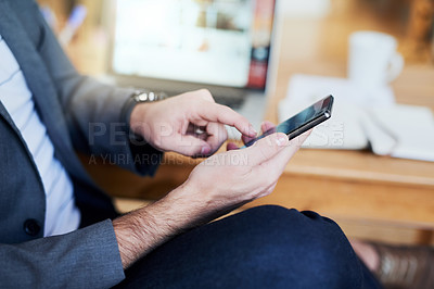 Buy stock photo High angle shot of an unrecognizable businessman sending a text message while sitting in the home office
