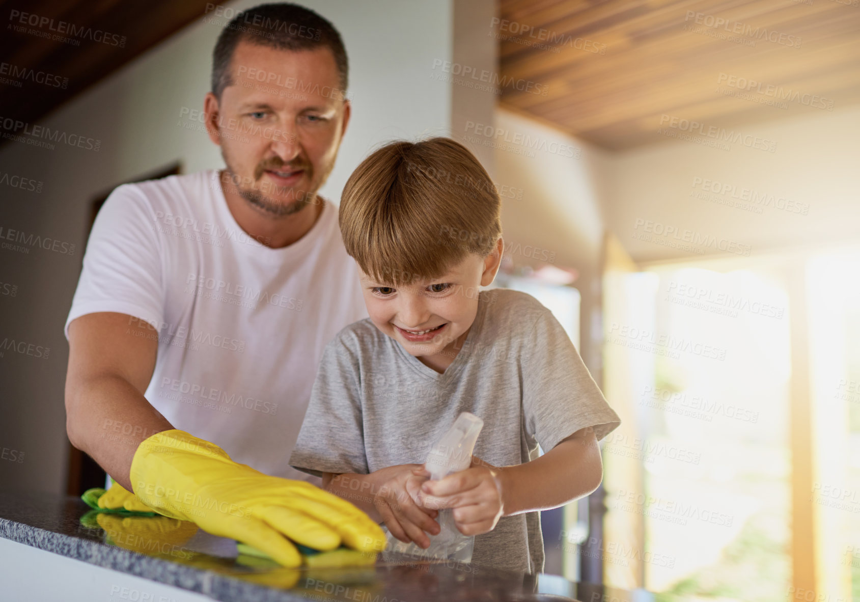 Buy stock photo Shot of a father and his little son doing chores together at home
