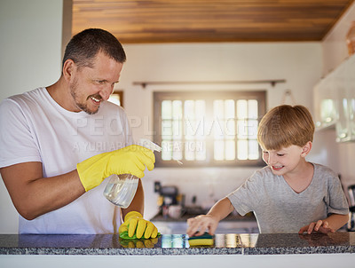 Buy stock photo Father, child and cleaning table with playing in home for helping hand, teaching hygiene and bonding. Family, man and boy kid with disinfectant to wipe surface in house for bacteria and chore support