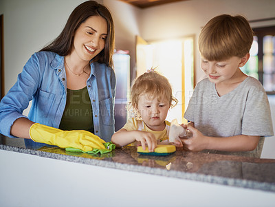 Buy stock photo Shot of a mother and her two little children doing chores together at home