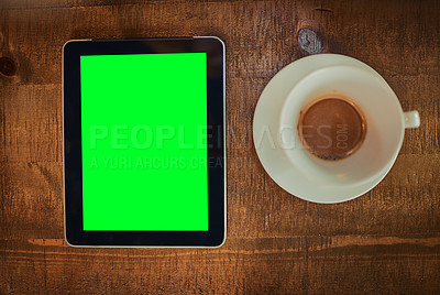 Buy stock photo High angle shot of a digital tablet with a green screen and cup of coffee on a table
