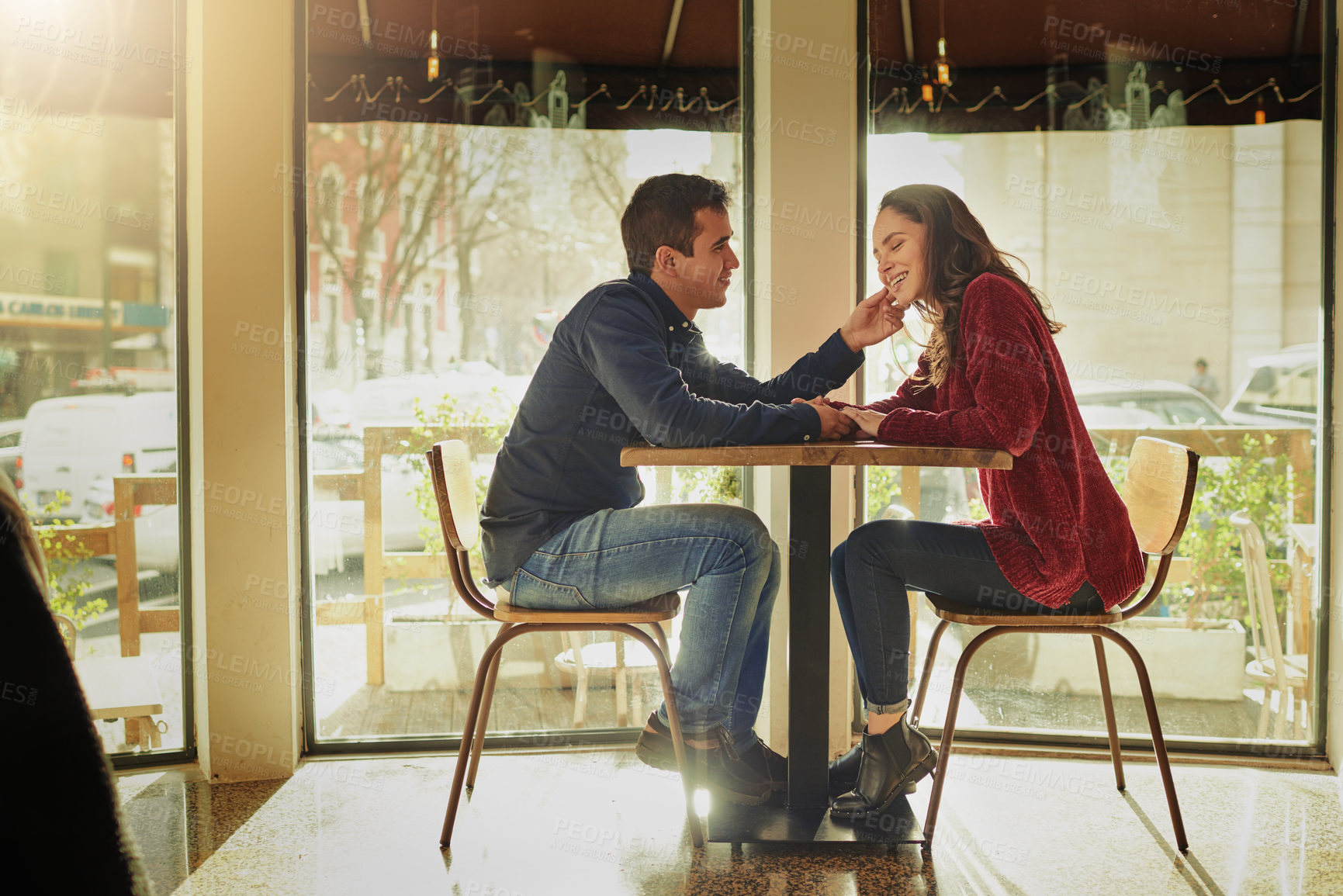 Buy stock photo Shot of a young man and woman on a romantic date at a coffee shop