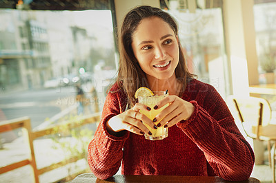 Buy stock photo Shot of a young woman enjoying a fresh beverage in a coffee shop