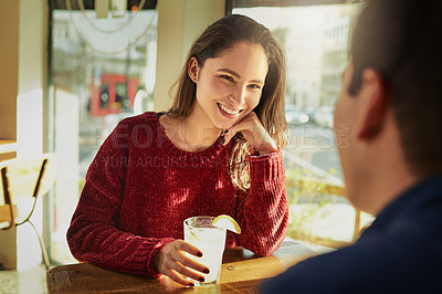 Buy stock photo Shot of a young man and woman on a romantic date at a coffee shop