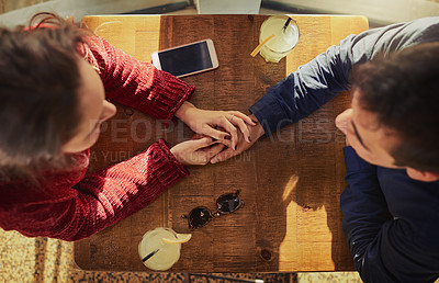 Buy stock photo High angle shot of a young man and woman on a romantic date at a coffee shop