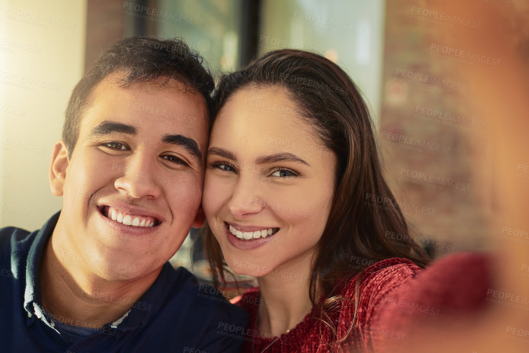 Buy stock photo Shot of a young man and woman taking selfies on a date at a coffee shop