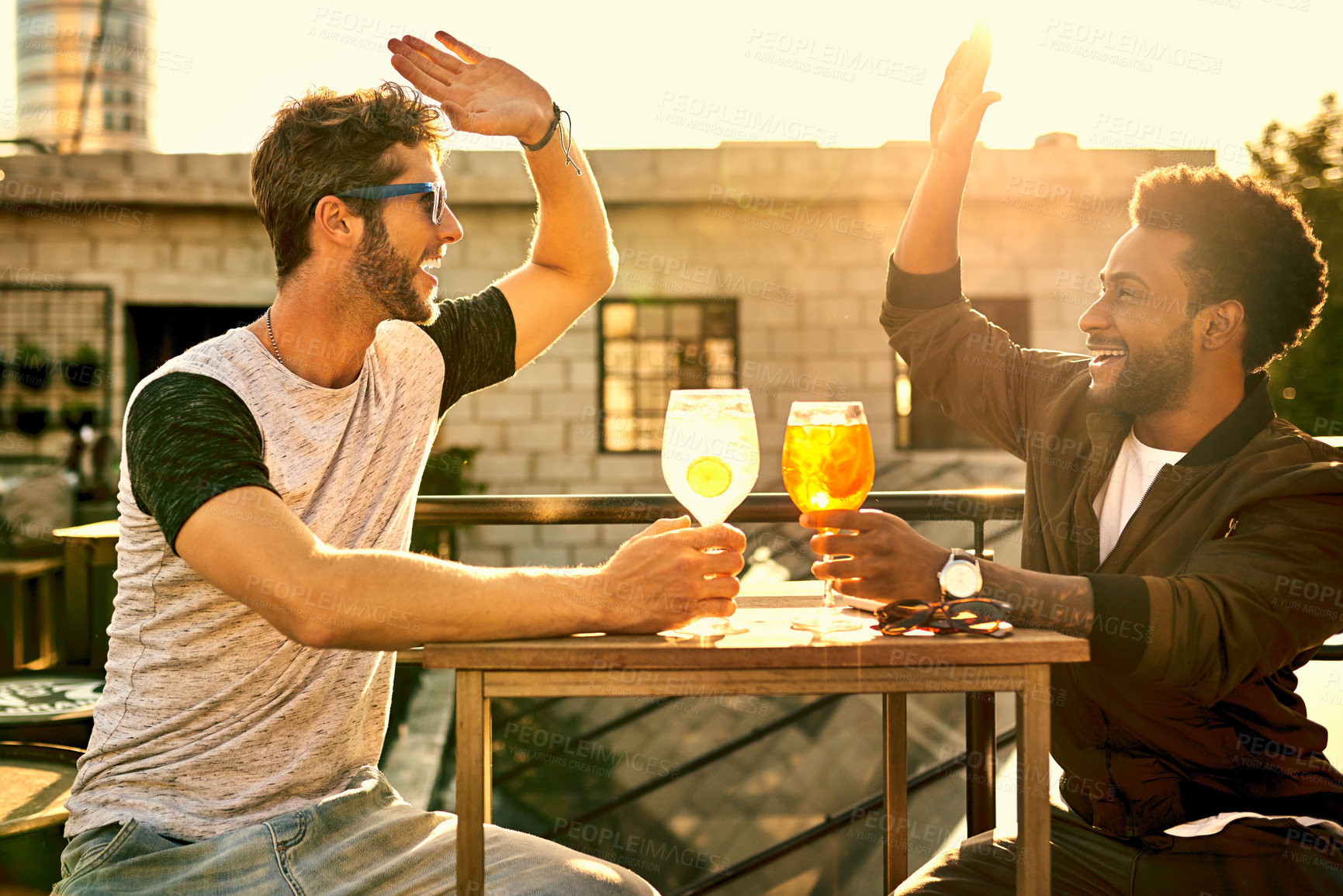 Buy stock photo Cropped shot of two male best friends spending the day outside on a rooftop