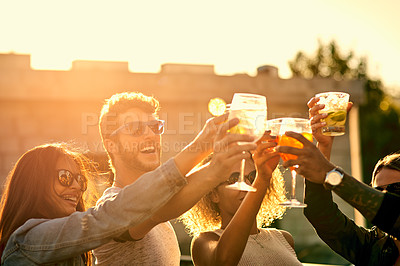 Buy stock photo Cropped shot of a group of young friends having a drink and spending the day outside on a rooftop