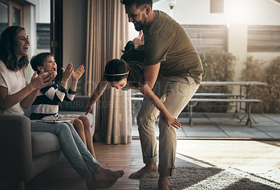 Buy stock photo Shot of a happy young family spending quality time together at at home