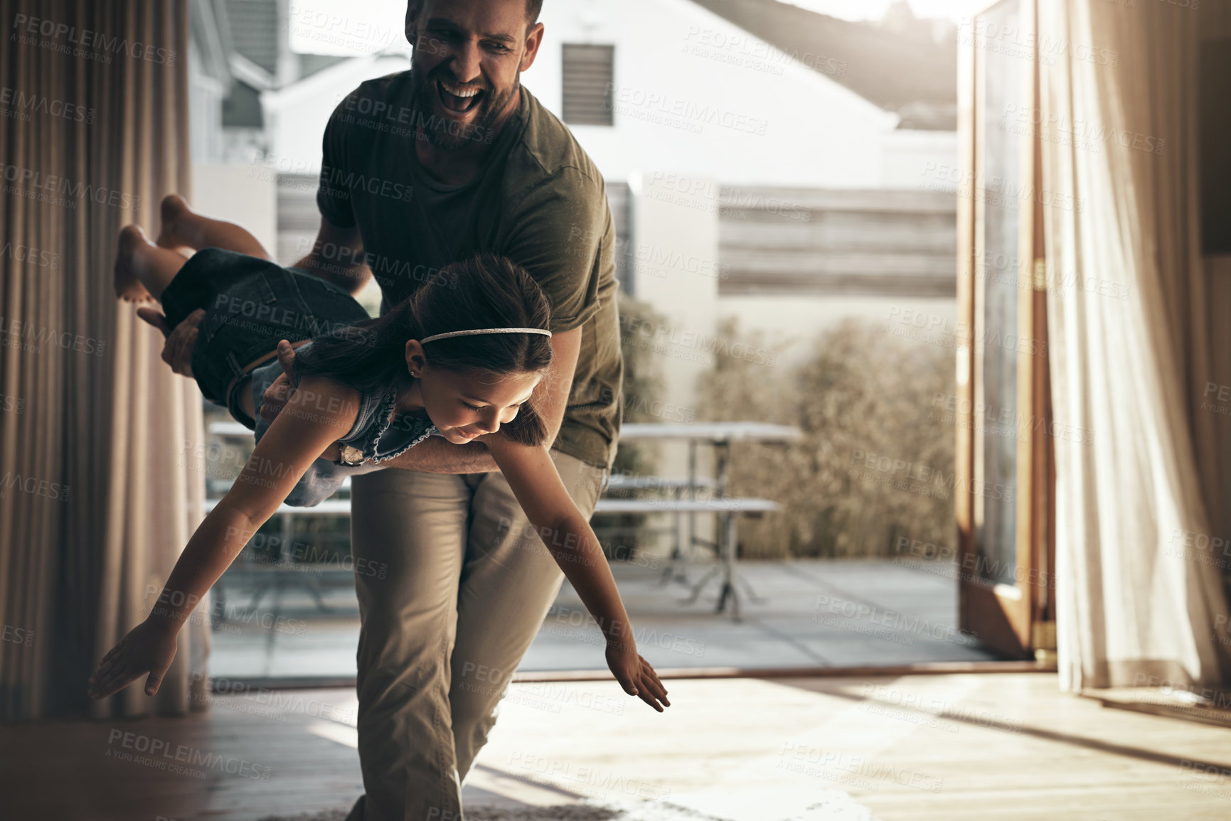 Buy stock photo Shot of a young man enjoying playtime with his daughter at home