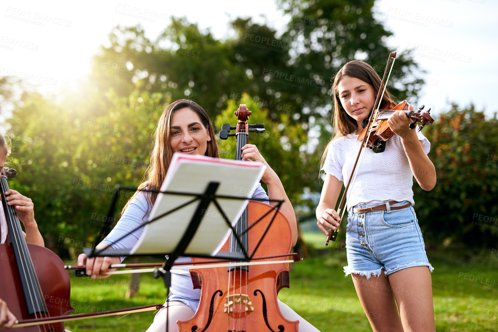 Buy stock photo Shot of a young girl playing a violin outdoors