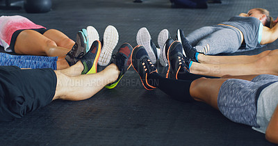 Buy stock photo Cropped shot of a group of people lying together in a circle during their workout at a gym