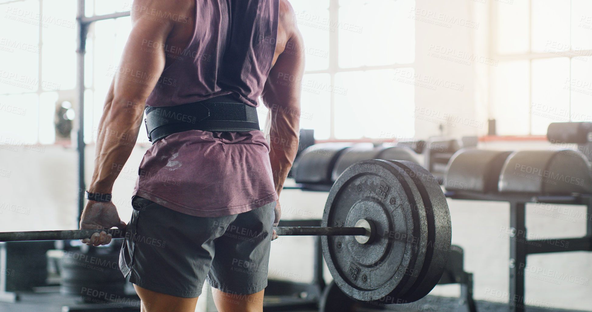 Buy stock photo Cropped shot of a muscular man lifting a barbell in a gym