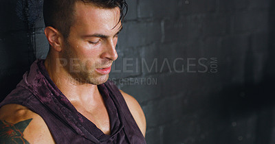 Buy stock photo Shot of a young man looking unhappy after his workout at a gym
