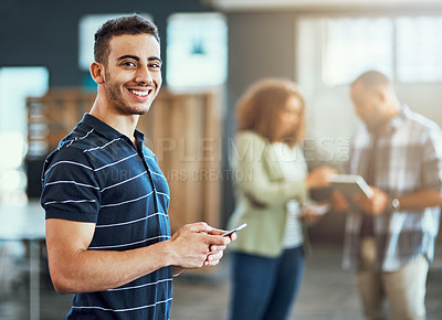 Buy stock photo Portrait of a young designer using a cellphone in an office