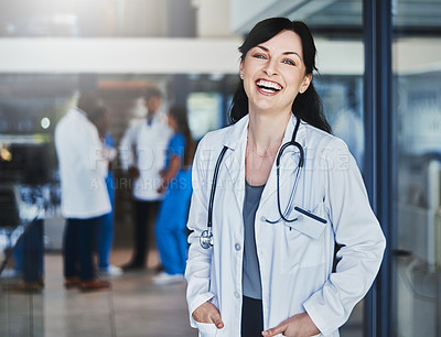 Buy stock photo Portrait of a confident doctor working in a hospital with her colleagues in the background