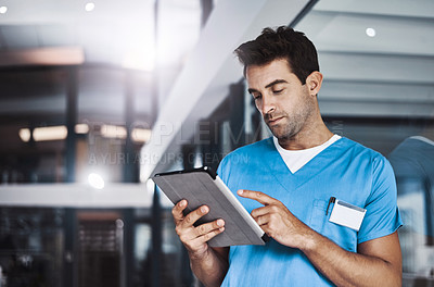 Buy stock photo Cropped shot of a young handsome male medical practitioner working in a hospital