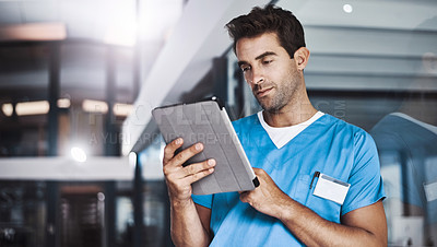 Buy stock photo Cropped shot of a young handsome male medical practitioner working in a hospital