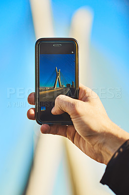 Buy stock photo Cropped shot of an unrecognizable man taking a photo of the city with his cellphone outside