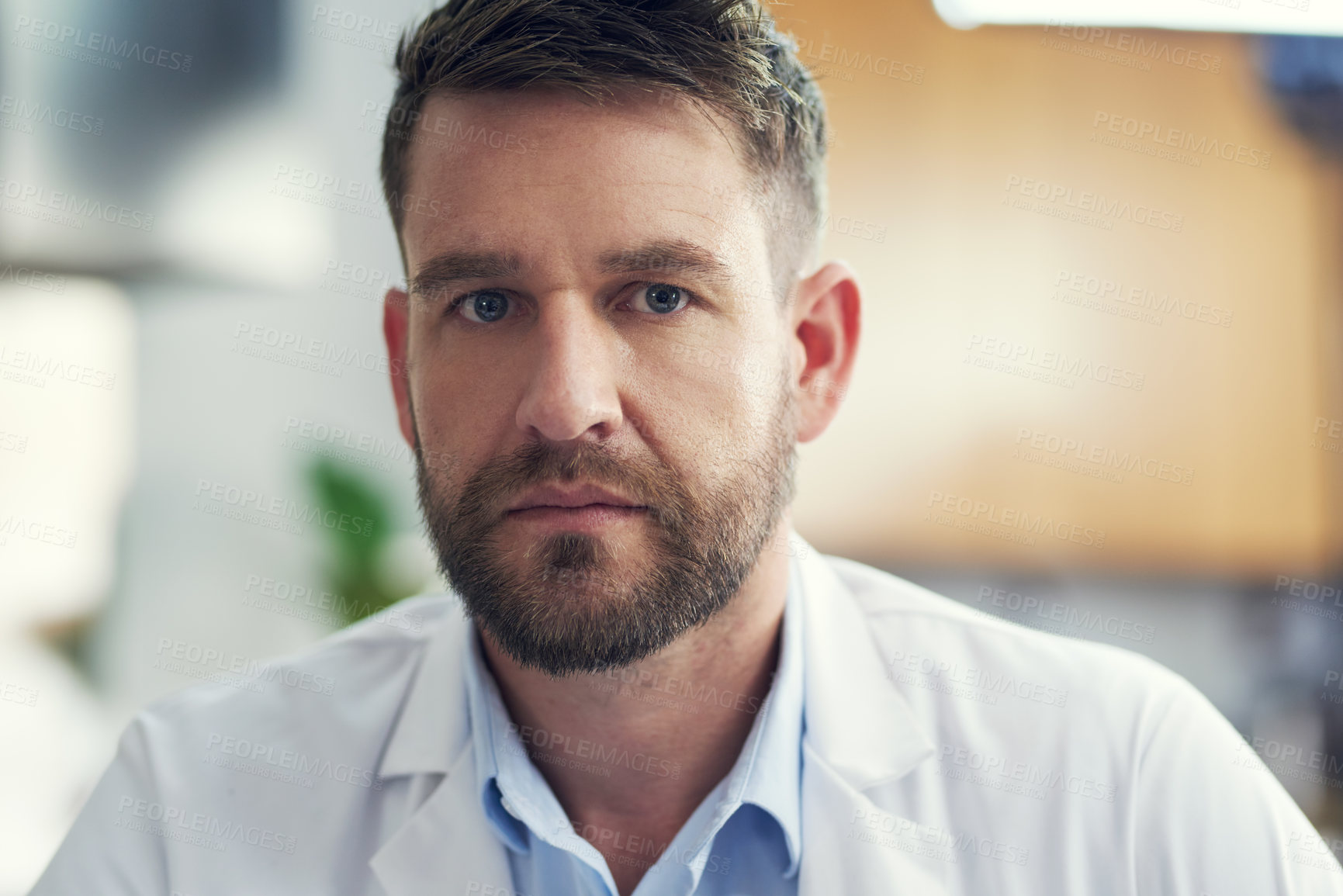Buy stock photo Cropped portrait of a handsome male doctor sitting in his office