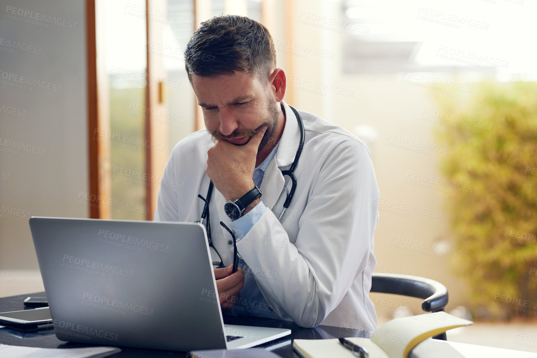 Buy stock photo Man, doctor and laptop with research, ideas and thinking in office as medical professional. Male person, pediatrician and diagnosis, telehealth and technology for patient records, medicine or surgery