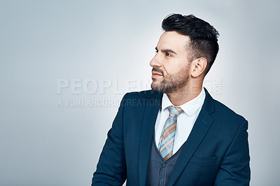 Buy stock photo Studio shot of a handsome young businessman looking thoughtful against a grey background