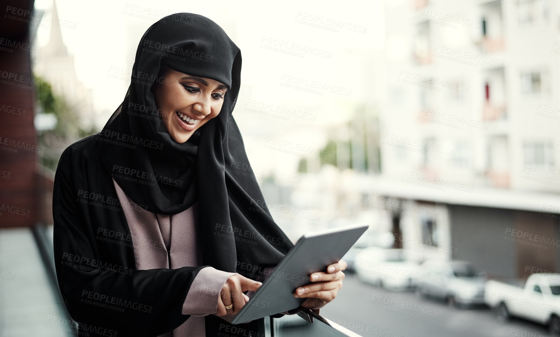 Buy stock photo Cropped shot of an attractive young businesswoman dressed in Islamic traditional clothing using a tablet while standing on her office balcony