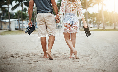 Buy stock photo Cropped shot of a young couple spending a romantic day at the beach