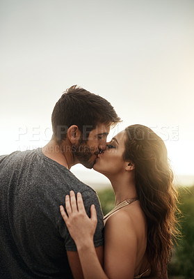 Buy stock photo Rearview shot of a young couple kissing at the beach