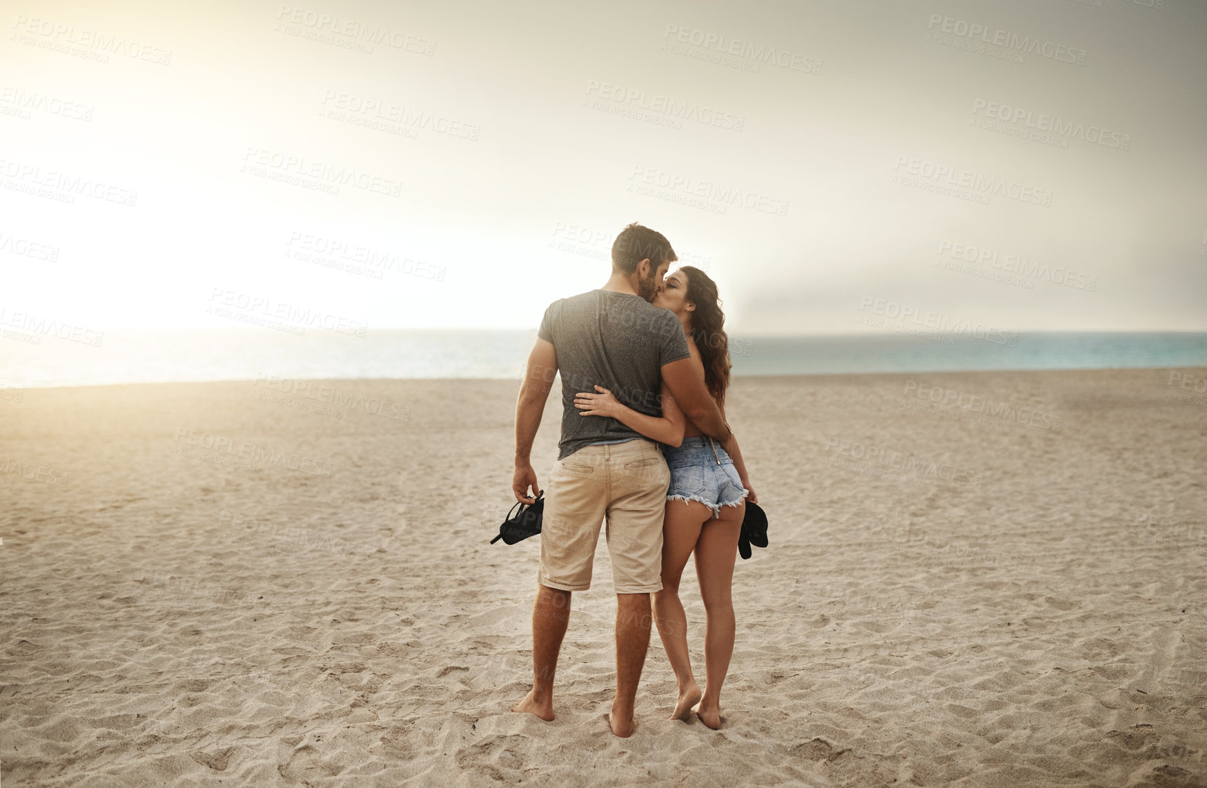 Buy stock photo Shot of a young couple spending a romantic day at the beach