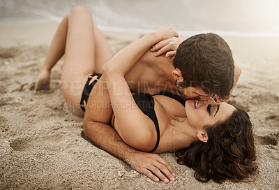 Buy stock photo Shot of a young couple kissing on the beach