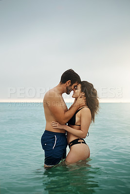 Buy stock photo Shot of a young couple enjoying a beach getaway