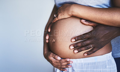 Buy stock photo Cropped shot of an unrecognizable man and his wife touching her pregnant belly