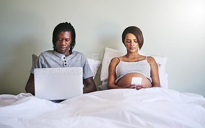 Buy stock photo Shot of a couple sitting in bed while using wireless devices