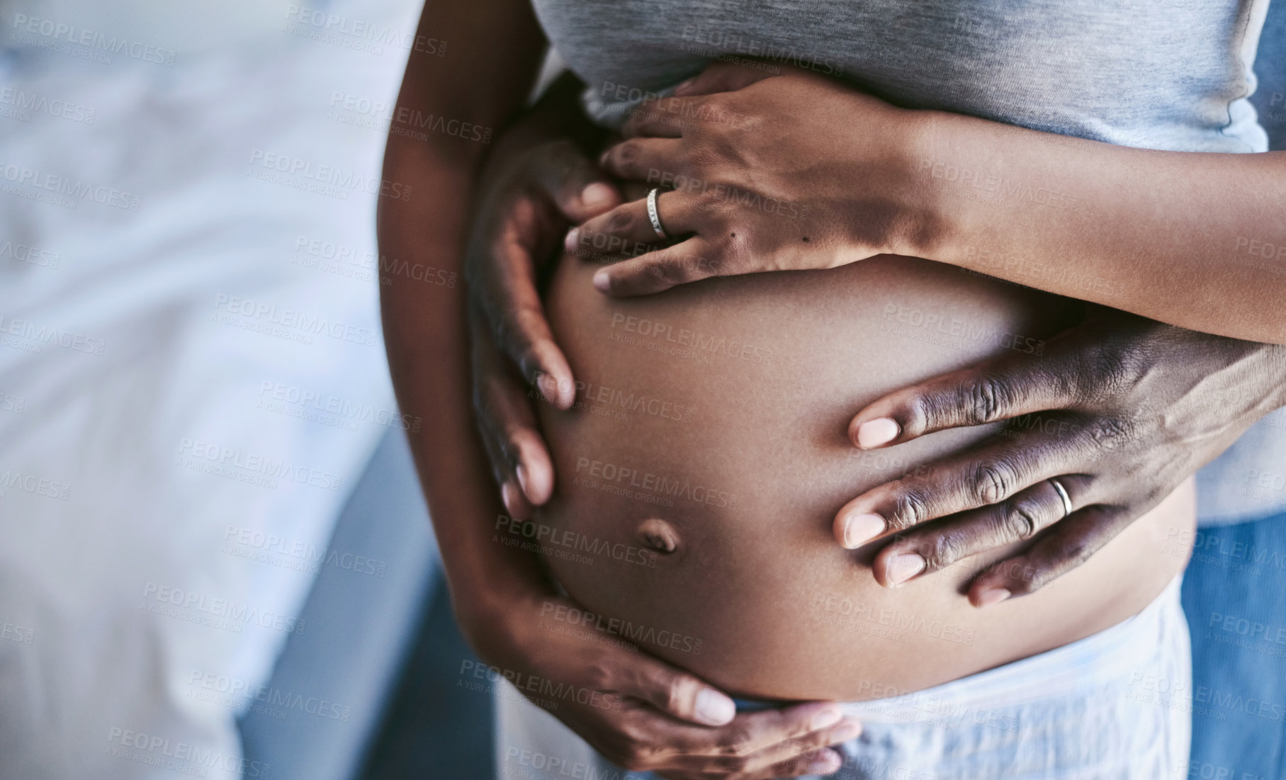 Buy stock photo Cropped shot of an unrecognizable man and his wife touching her pregnant belly
