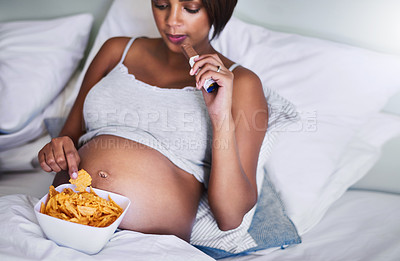 Buy stock photo Cropped shot of a pregnant woman enjoying a chocolate and potato chips in bed