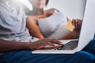 Buy stock photo Shot of a young couple doing some online shopping with a credit card