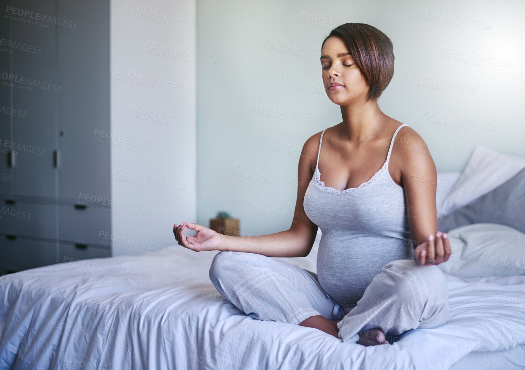 Buy stock photo Shot of a pregnant woman doing yoga in her bedroom