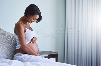 Buy stock photo Shot of a young pregnant woman sitting in her bedroom