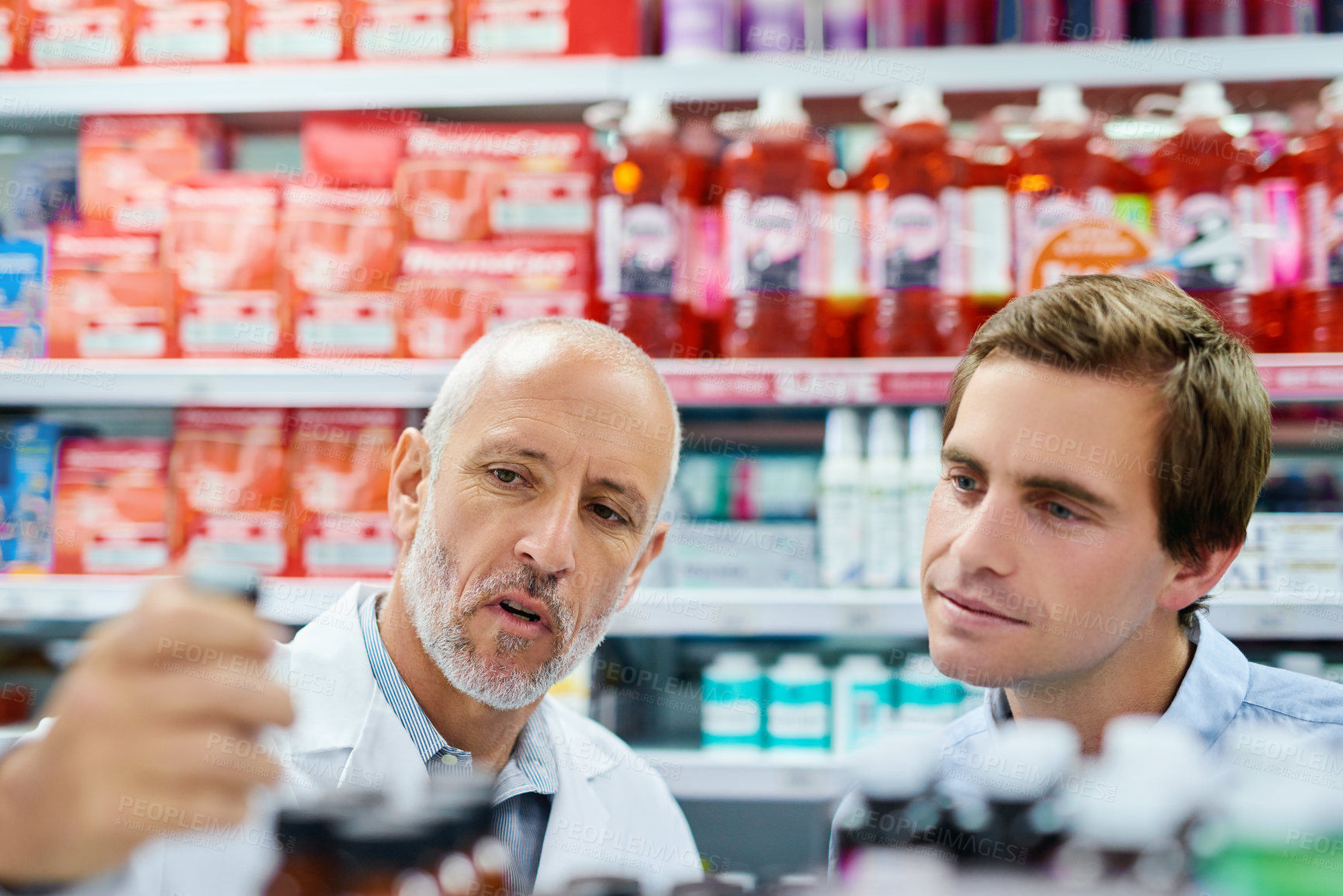 Buy stock photo Shot of a pharmacist assisting a customer in a chemist