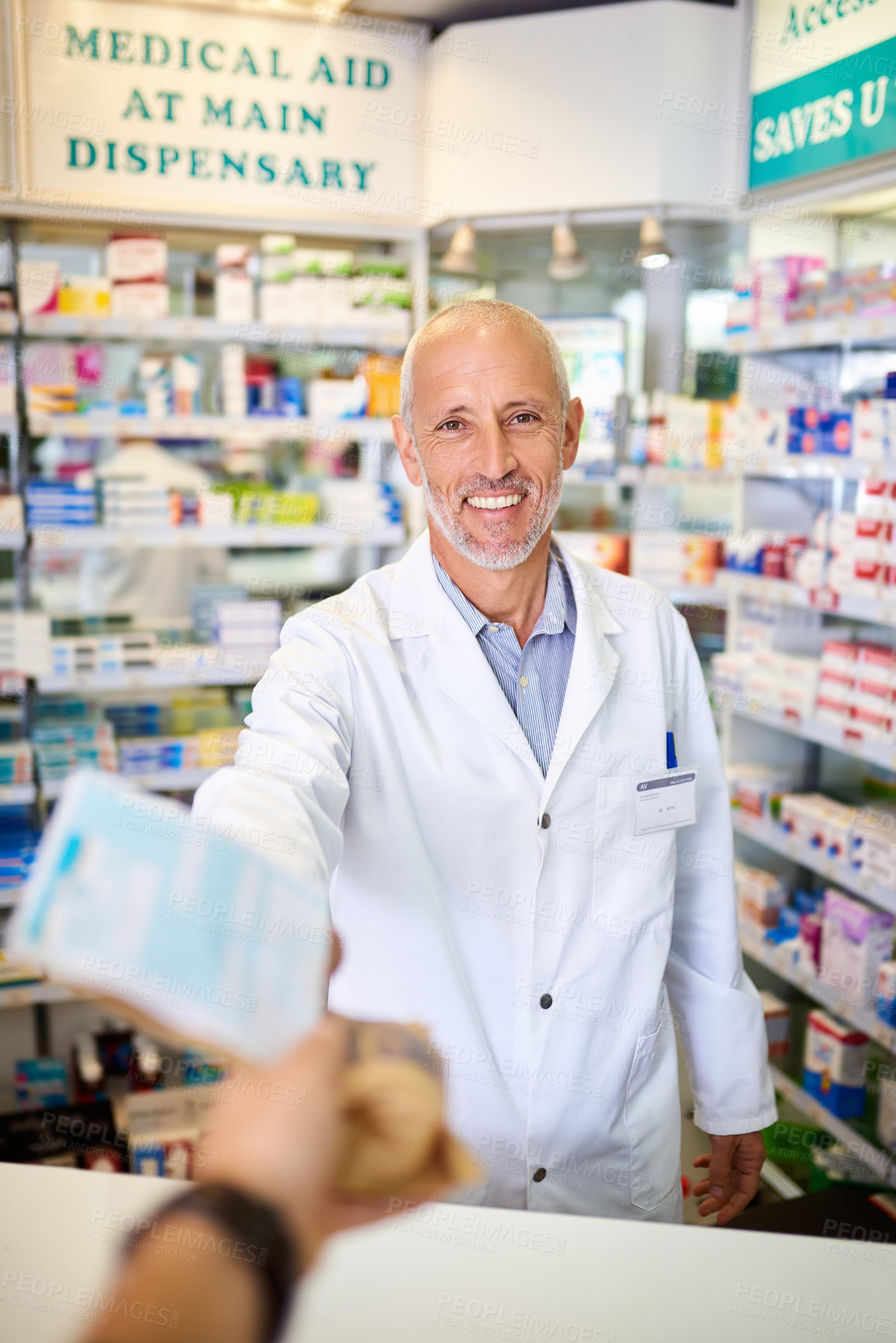 Buy stock photo Personal perspective shot of a pharmacist handing over medication to a customer in a chemist