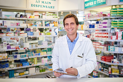 Buy stock photo Portrait of a young pharmacist writing on a clipboard in a chemist