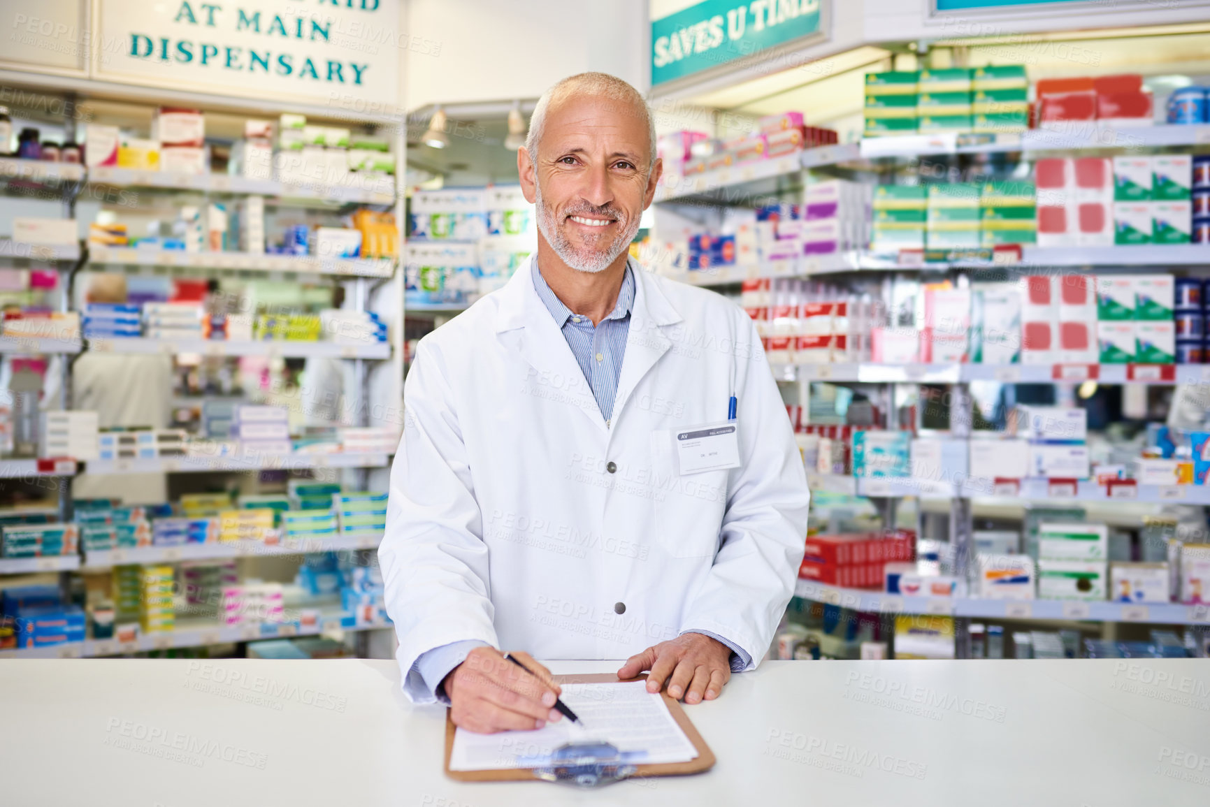 Buy stock photo Portrait of a mature pharmacist writing on a clipboard in a chemist