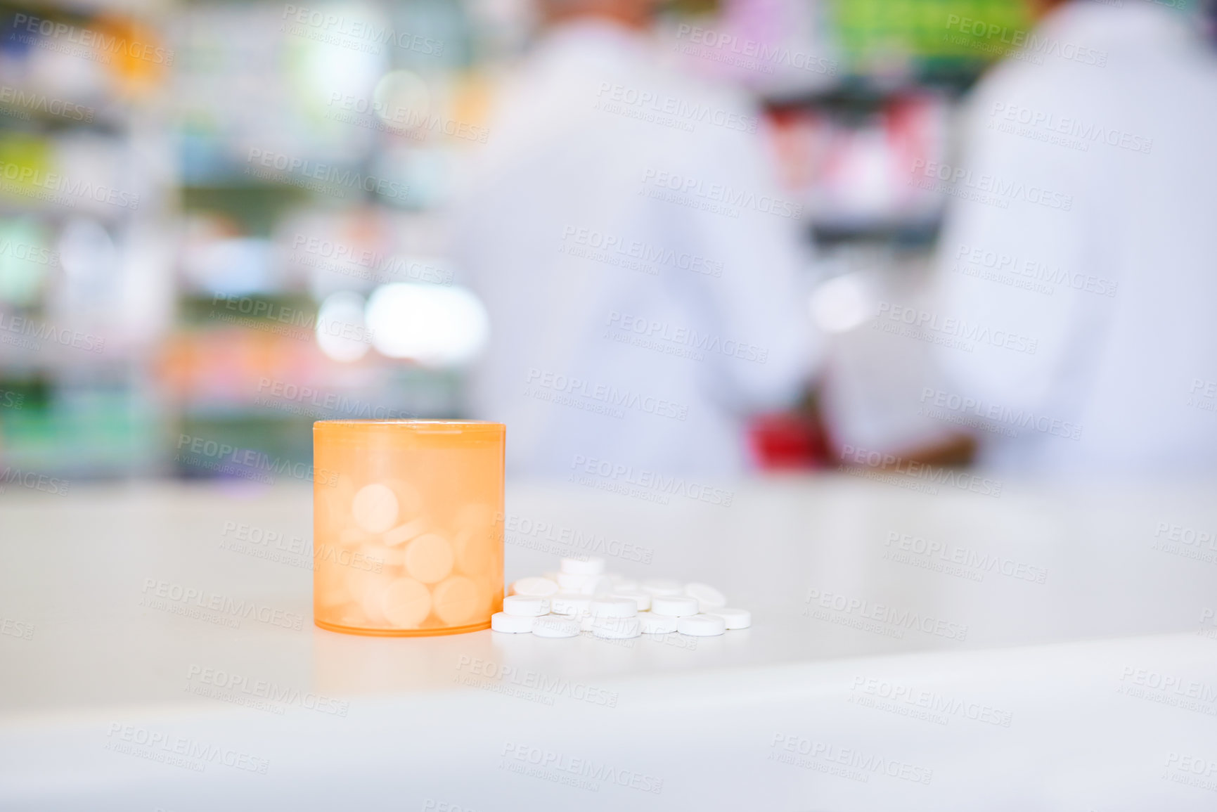 Buy stock photo Shot of a container filed with medication on a counter in a pharmacy