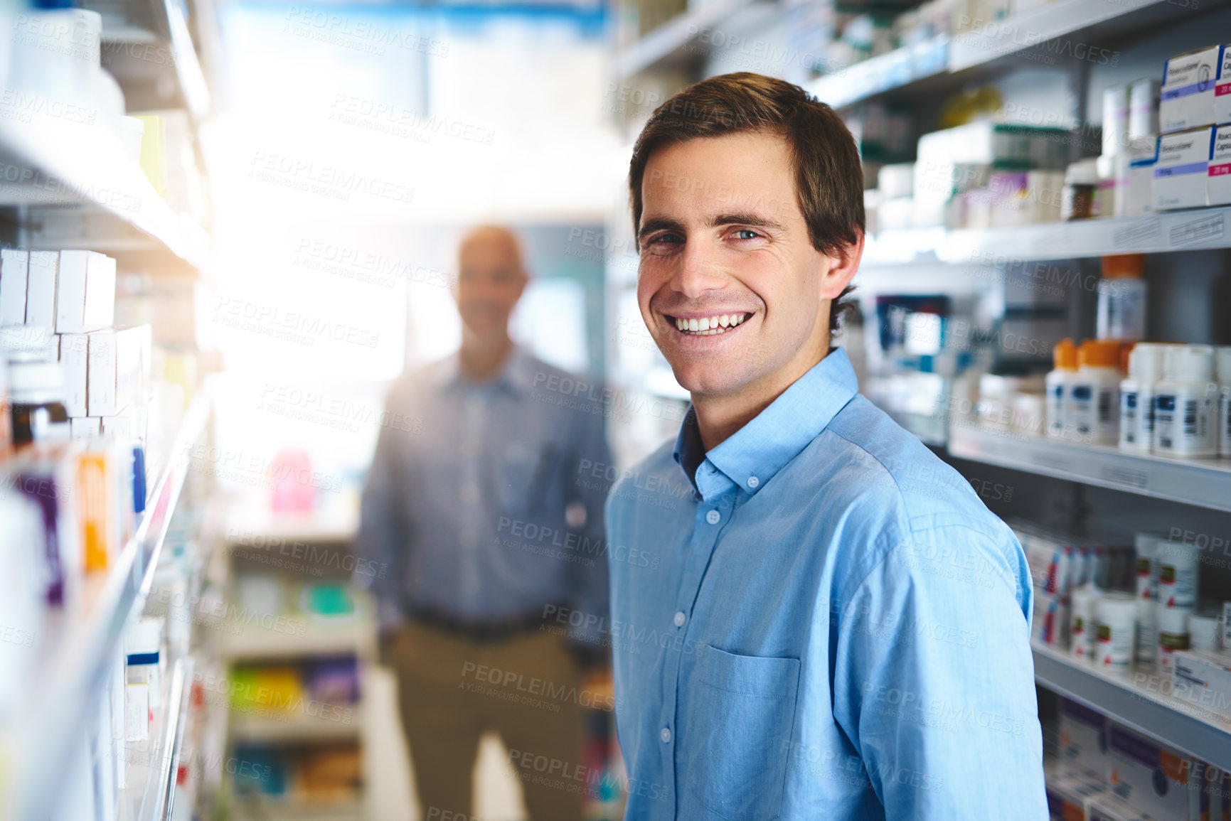 Buy stock photo Cropped portrait of a handsome young man looking for medication in a pharmacy