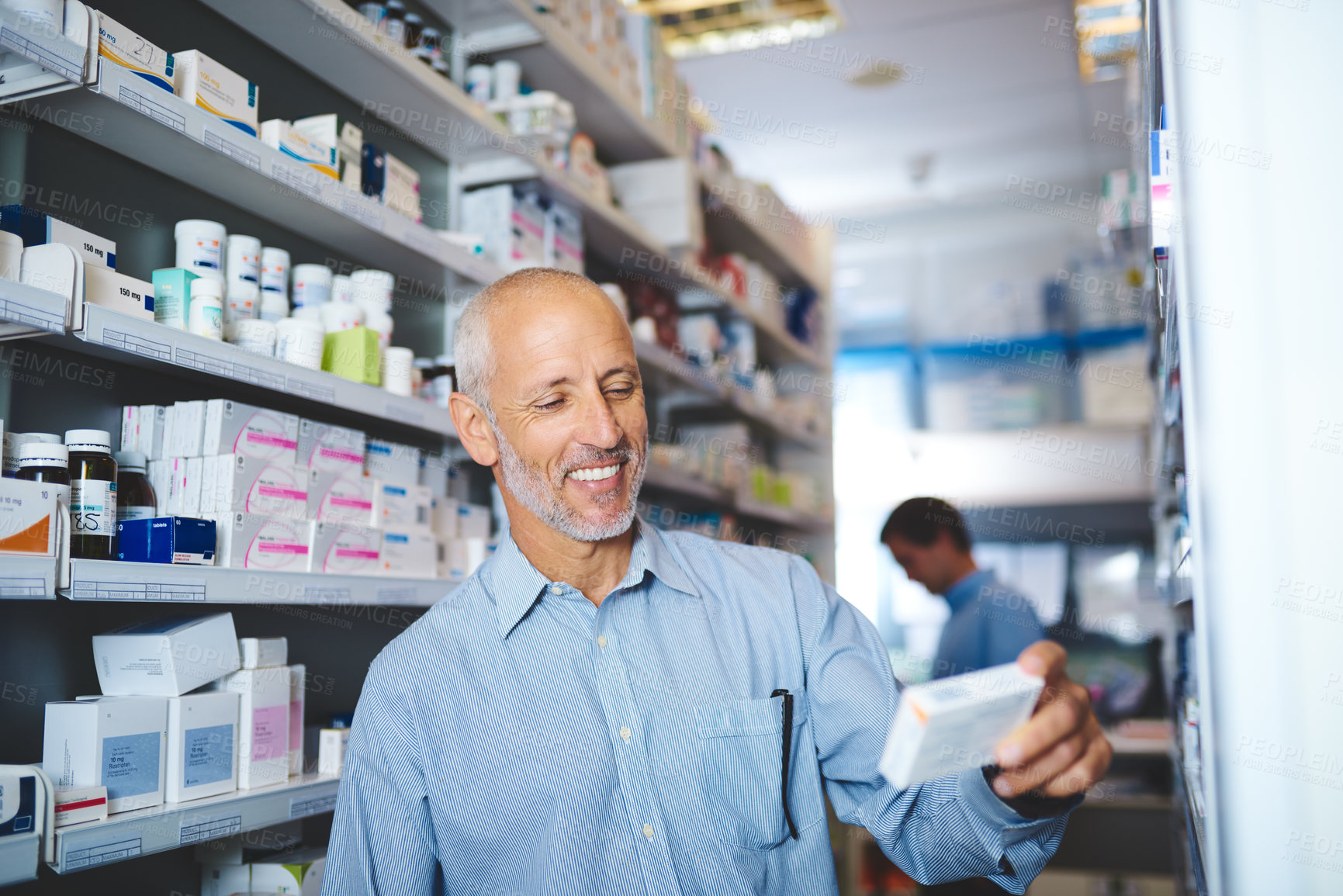 Buy stock photo Cropped shot of a handsome mature man looking for medication in a pharmacy