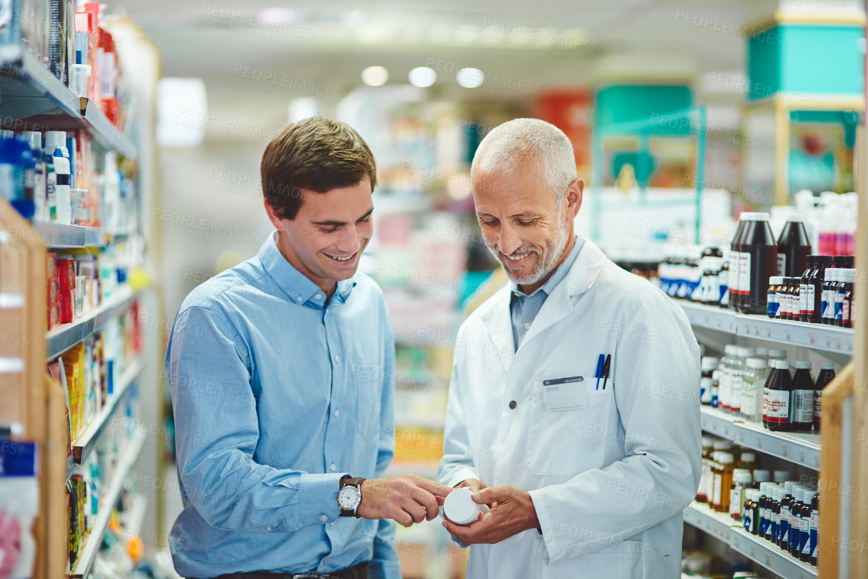 Buy stock photo Cropped shot of a handsome mature male pharmacist helping a customer in the pharmacy