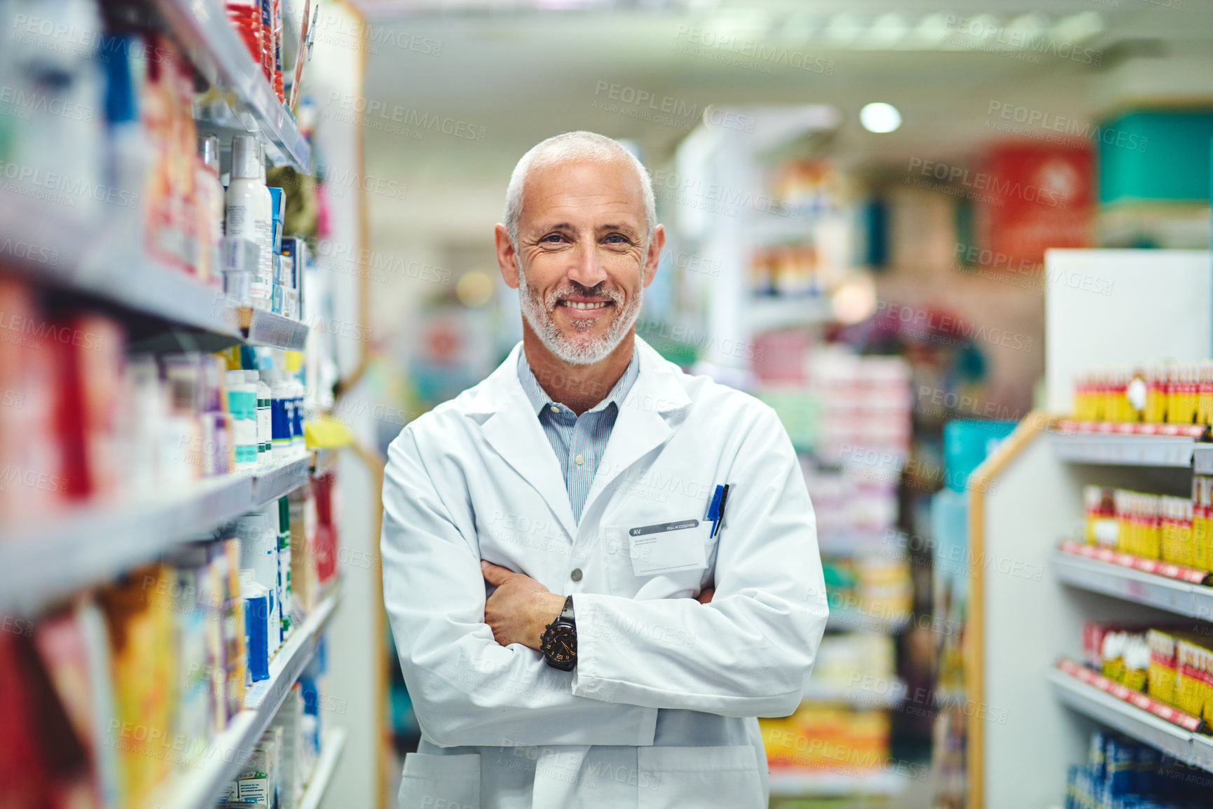 Buy stock photo Cropped portrait of a handsome mature male pharmacist standing with his arms crossed in the pharmacy