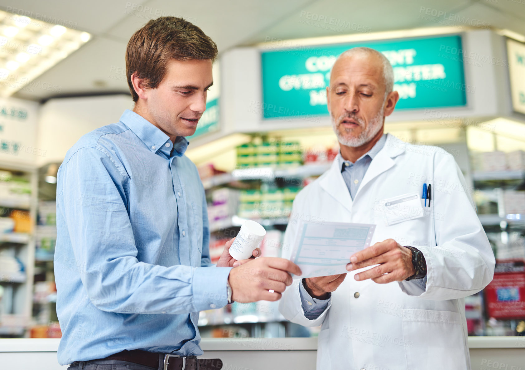 Buy stock photo Cropped shot of a handsome mature male pharmacist helping a customer in the pharmacy