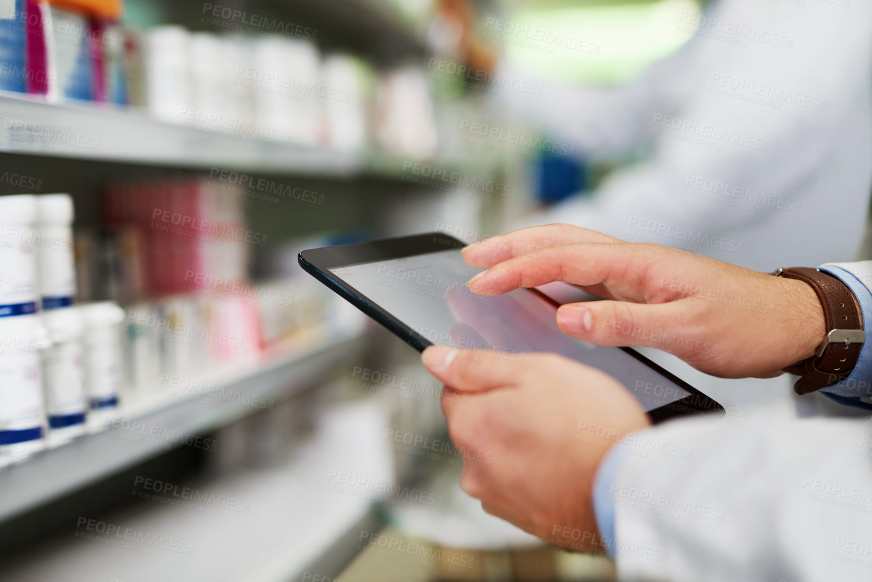 Buy stock photo Cropped shot of a pharmacist using a digital tablet in a pharmacy